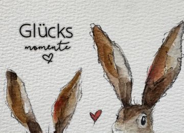 Eine Postkarte mit zwei Hasen und dem Spruch Glücksmomente