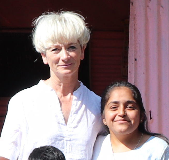 Frau steht neben einem indischen Kind